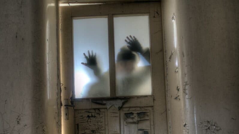 man leaning on frosted glass panel door